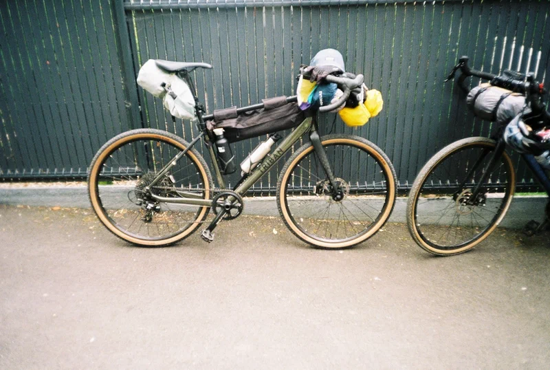 Deux vélos de bikepacking chargés de sacoches contre une palissade