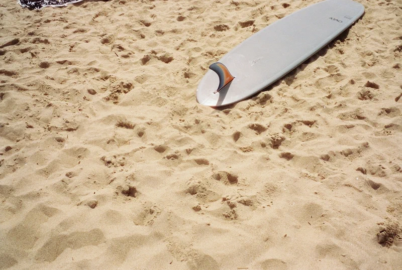 Planche de surf posée dans le sable