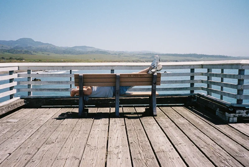 Banc sur une jetée en bois face aux collines