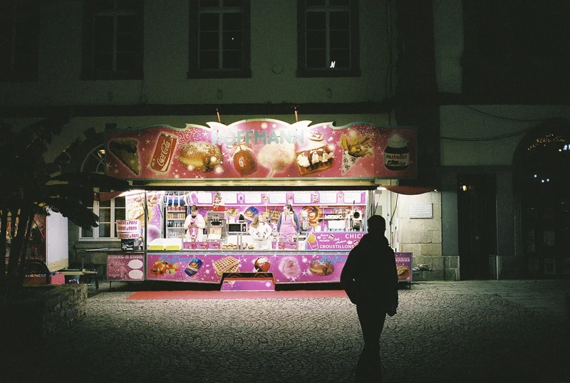Silhouette devant une baraque à confiseries de fête foraine la nuit