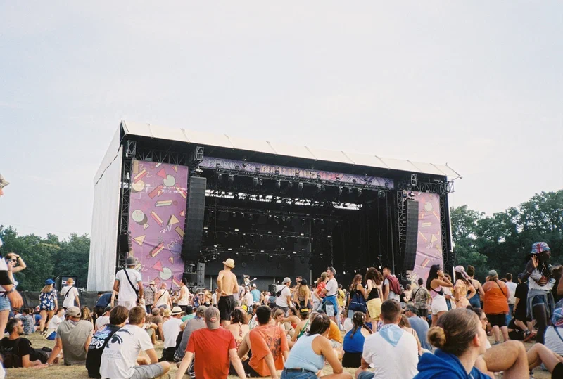 Public assis devant une grande scène de festival