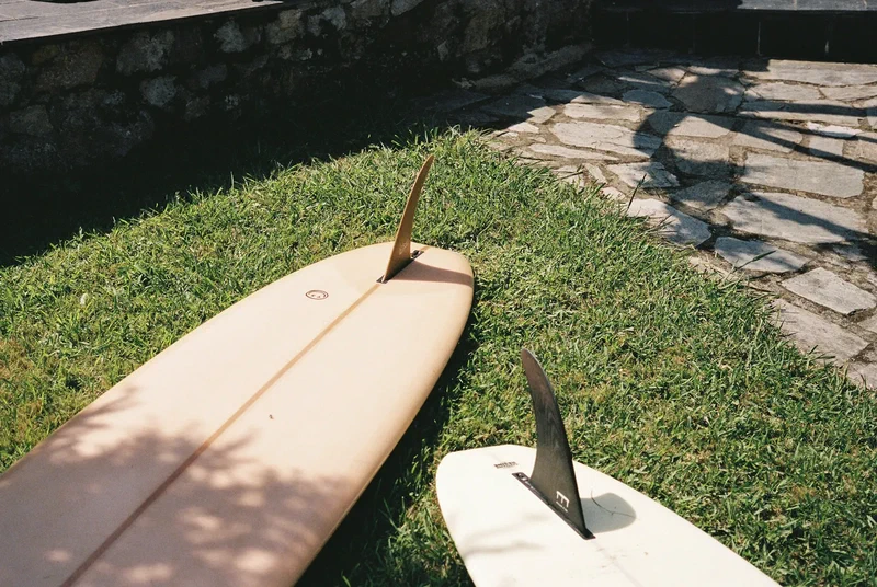 Two surfboards lying fins up on the lawn