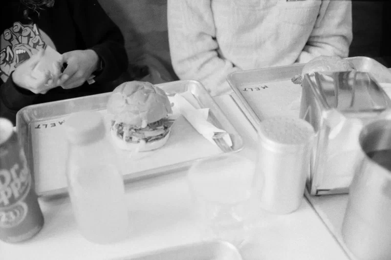 Burger and drinks on a tray, black and white