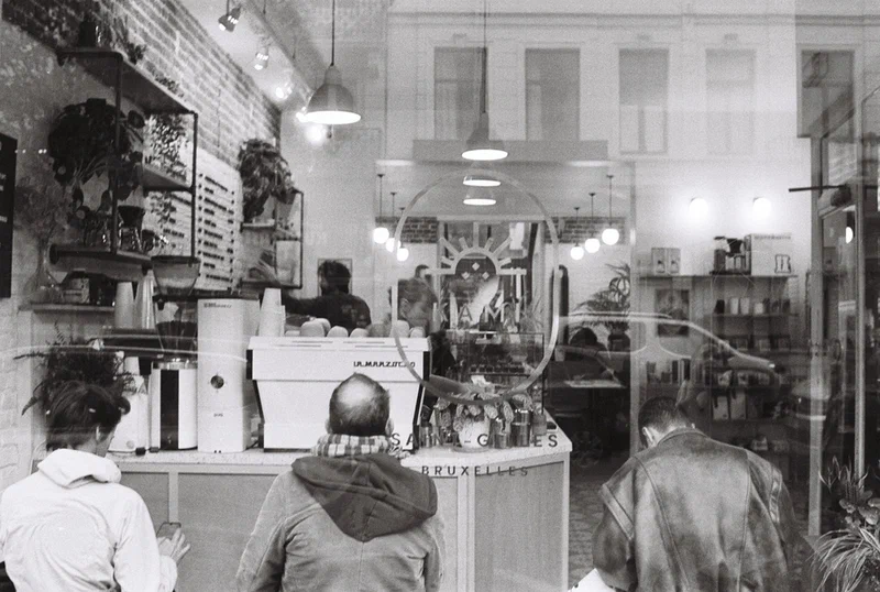 Customers at the counter of a coffee shop, black and white