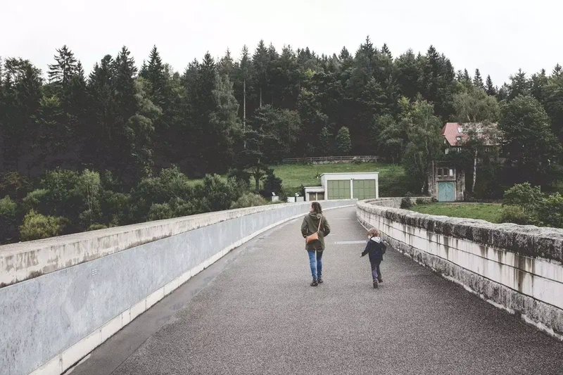 Deux silhouettes qui marchent sur la route du barrage
