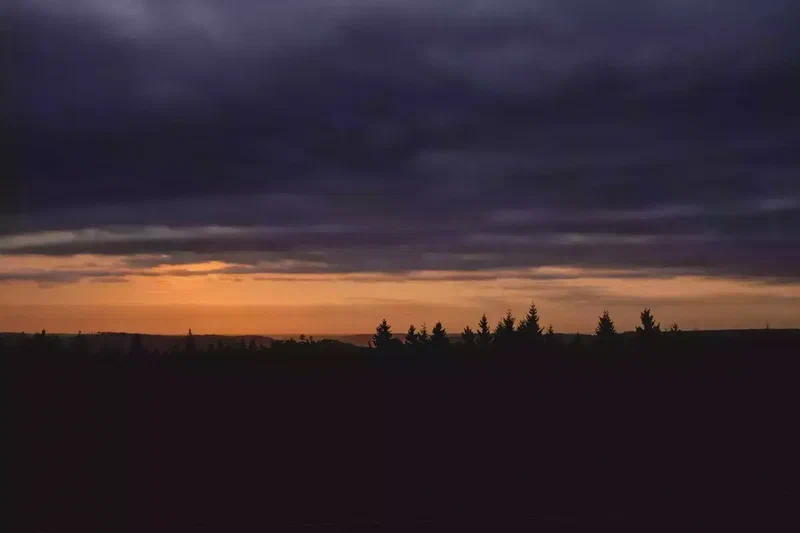 Coucher de soleil orange sous des nuages sombres