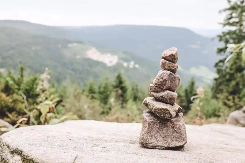 Cairn sur un rocher avec vue sur la vallée