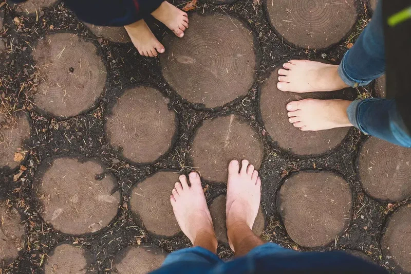 Pieds nus sur des rondins du sentier pieds nus
