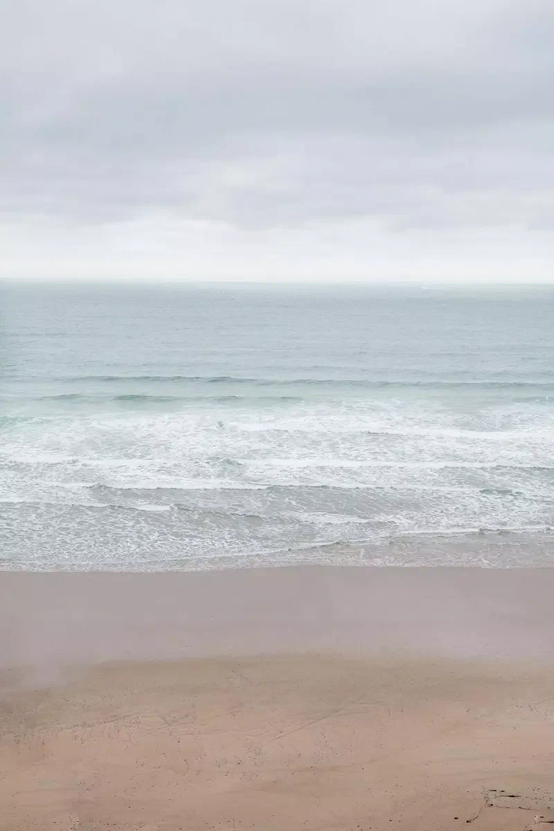 Plage de la Palue sous un ciel gris, vagues au loin