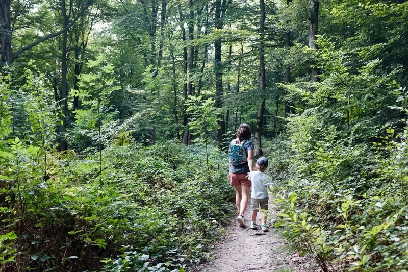 Une mère et son fils qui descendent un sentier dans la forêt