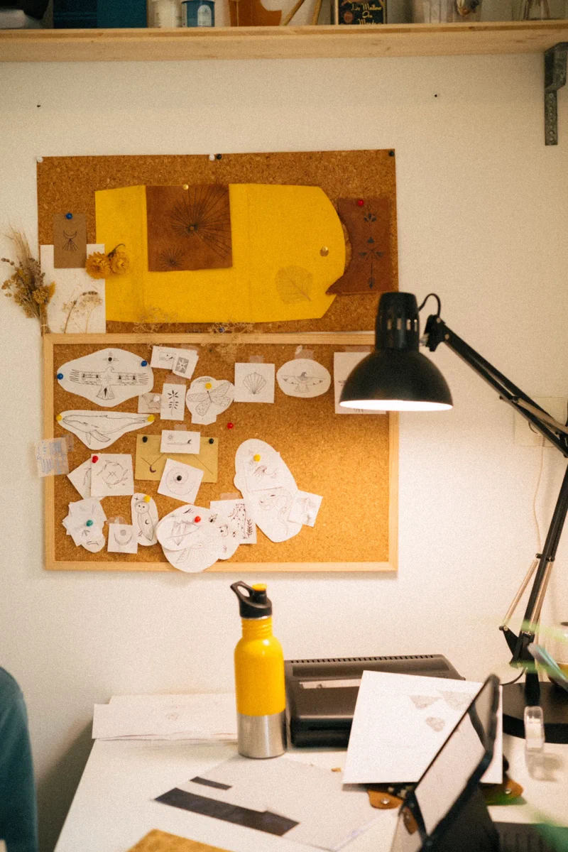 Bureau avec des croquis épinglés sur un panneau de liège