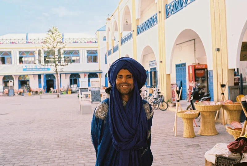 Homme en turban bleu sur une place de la médina