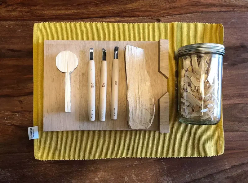 Outils à cuillère en bois et bocal de copeaux sur un set de table jaune