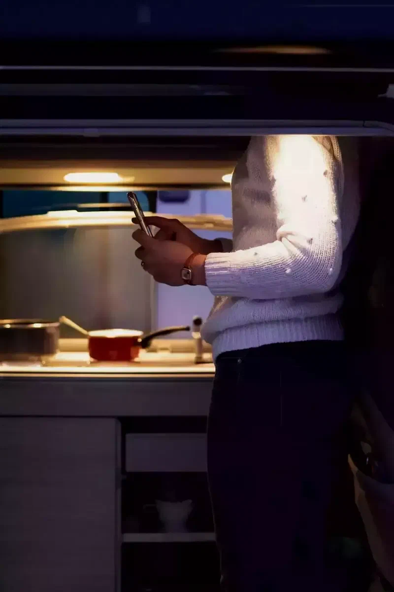 Femme qui cuisine dans le van le soir